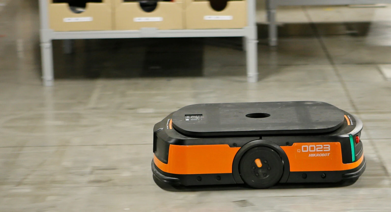 Intelligenter mobiler Roboter beim Lastentransport auf dem Lagerboden